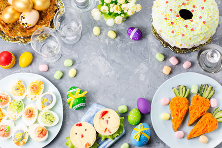 Funny colorful Easter food for kids with decorations on table. Easter dinner concept, top view