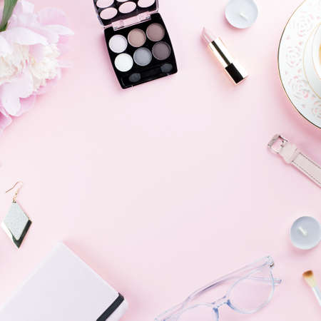 Beautiful cosmetics and flowers flat lay with note book, herbal tea on pastel background.の写真素材