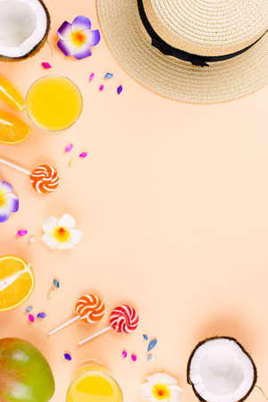Colorful summer concept flat lay with fresh juice, tropical fruits, lollipops and multicolor seashellsの写真素材