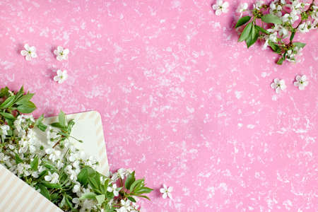 Spring blossom. Cherry flowers in envelope box flat on pastel background. Greeting card with white flowers , copy spaceの写真素材
