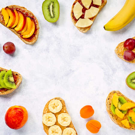 Healthy breakfast sweet toasts with different fruits and berries on wooden table. Copy space, top viewの写真素材