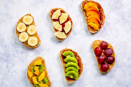 Healthy breakfast sweet toasts with different fruits and berries on wooden table. Copy space, top viewの写真素材