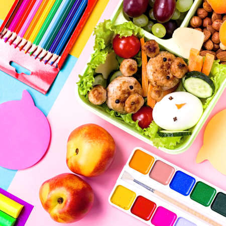School lunchbox with healthy snack and funny foods- cutlets, vegetables, fruits, nuts. Back to school background.の写真素材