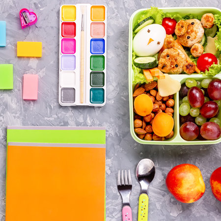 School lunchbox with healthy snack and funny foods- cutlets, vegetables, fruits, nuts. Back to...