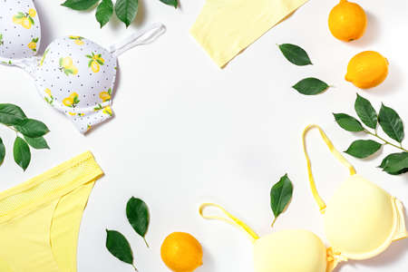 Summer girl cotton lingerie with lemons on white background, copy space. Flat lay, top view. Summer fashion conceptの写真素材