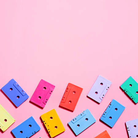 Painted multicolor audio cassettes on pink background, copy space, top view. Retro musical backgroundの写真素材