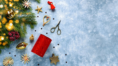 Christmas card with fir tree branches, red ribbons and decorations, wooden ornaments, confetti. Copy space, top viewの写真素材