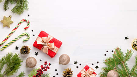 Christmas card with fir tree branches, golden decorations, sweets and pine cones . Festive Christmas backgroundの写真素材