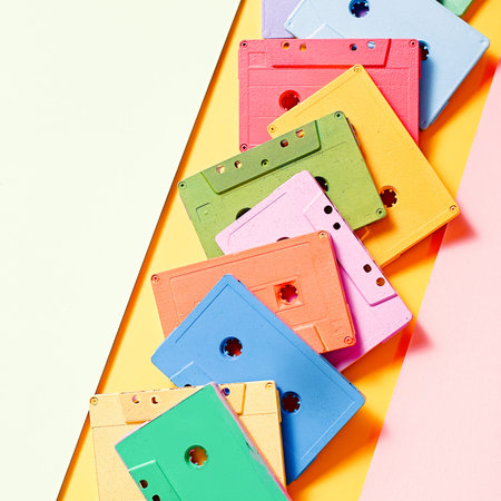 Red, green, blue, yellow retro audio cassettes flat lay background