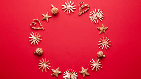 Christmas natural wood decorations frame on red background, copyspace. Flat lay, christmas card with ornaments from ecological materialsの写真素材