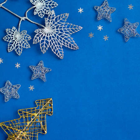 Ornate Christmas decorations frame on classic blue color background. Silver, golden and red ornaments flat lay, background for Christmas, New Year, copy spaceの写真素材