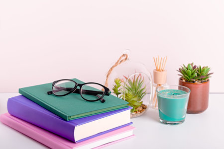 Multicolor books stack, house plants succulents and fragrant candle and sticks. Background for World...