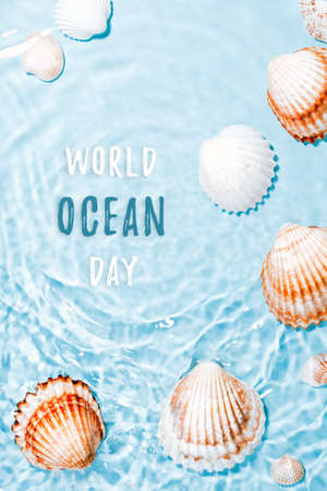 Beautiful crystal clear water swirling, sea shells underwater. World ocean day card with text, shells and blue water. Global environmental problem conceptの写真素材