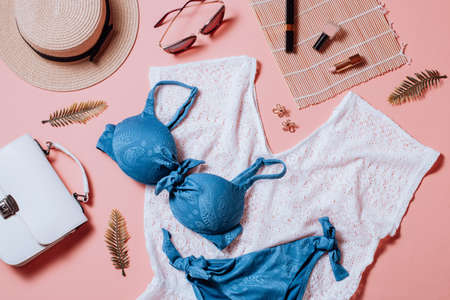 Fashion female clothes and accessories for beach destinations or summer vacation. Flat lay with woman white clothing, straw hat and purse, make up on white background, woman travel fashion conceptの写真素材