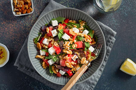 Summer refreshing salad with watermelon, feta cheese, walnuts and greens on black table top with lemon water, top view. Recipe for heat waveの写真素材