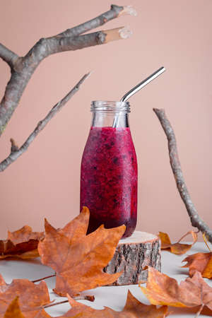 Immune system boosting red berries smoothie with raspberry and blackberry on wooden stand for autumn or virus season on neutral background with natural elements, minimal style still lifeの写真素材