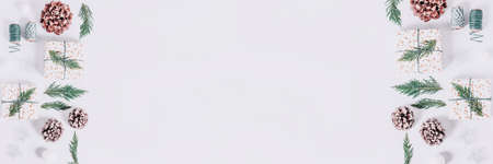 Border with wrapped presents with cedar and cones on white background. Preparation for Christmas holiday concept, christmas border, web banner, copy space, square formatの写真素材