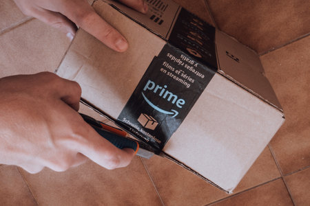 EMPURIABRAVA, SPAIN- JUNE 12, 2020: Man opening Amazon Prime package delivery, top view, closeupのeditorial素材