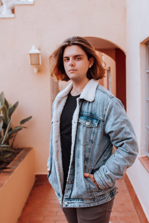 Lifestyle portrait of gen z teenage boy in denim jacket outdoors in empty street