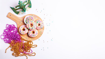 Mardi gras donuts and beads, holiday celebration baking, top viewの写真素材