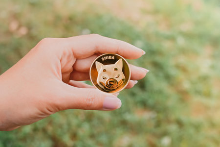 Empuriabrava, Spain, June 2021 - Woman holding one Shiba token, coin with Shiba symbol, concept of investing in Shiba tokenのeditorial素材