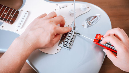 Guitar master repairing electric guitar, top view, closeupの写真素材