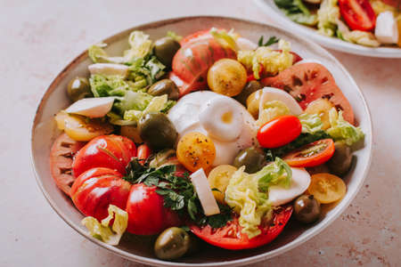 Fresh mediterranean salad with tomatoes and burrata cheese, top viewの写真素材