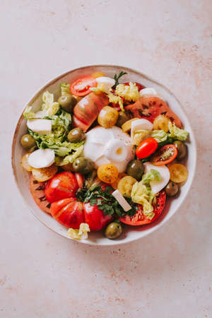 Fresh mediterranean salad with tomatoes and burrata cheese, top viewの写真素材