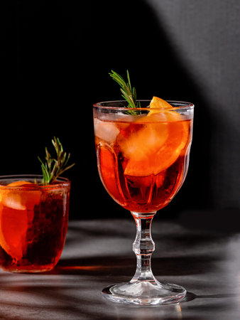 Negroni cocktail with smoking rosemary and orange garnish on black background, minimal styleの写真素材