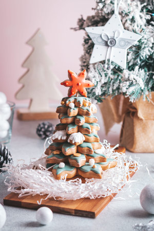 Gingerbread Christmas tree on table with seasonal decor and natural pine cones on bright background
