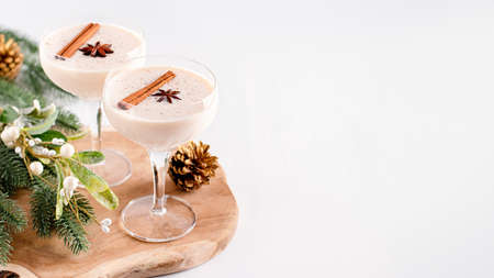 Eggnog on wooden tray, Christmas cocktail in coupe glass, top viewの写真素材