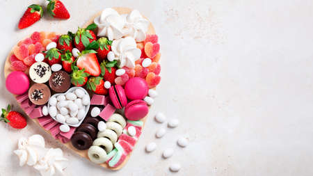 Valentines day charcuterie board with macaroons, strawberry and chocolate cookiesの写真素材