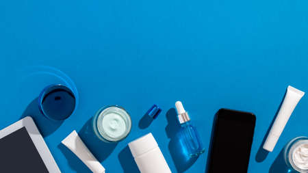 Skin care cosmetics protecting from gadgets blue light on blue backgroundの写真素材
