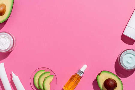 Avocado skin care cosmetics flat lay frame on pinkの写真素材