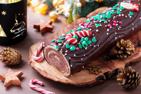 Traditional chocolate trunk cake or log cake on table with Christmas decorationsの写真素材