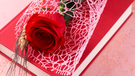 Red rose and red book on pink background, Sant Jordi holiday cardの写真素材