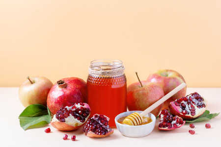 Apples, jar of honey and pomegranates on tray for Jewish holiday Rosh Hashanah on neutral background, copy spaceの写真素材