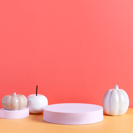 Empty product podium with autumn ceramic white pumpkin decor in pastel pink and orange colors. autumn product display conceptの写真素材