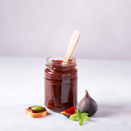 Autumn preserves from local produce, fig jam or fig marmalade on light gray table with fresh, ripe figs, copy spaceの写真素材