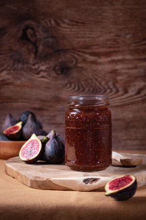 Autumn preserves, fig jam or fig marmalade on wooden board with fresh, ripe figs, still lifeの写真素材
