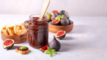 Autumn preserves from local produce, fig jam or fig marmalade on light gray table with fresh, ripe figs, copy spaceの写真素材