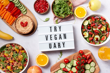 Vegan or veganuary feast with various salads ad healthy plates on light gray tableの写真素材