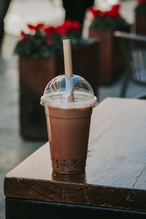 Glass of chocolate bubble tea closeup in street cafe