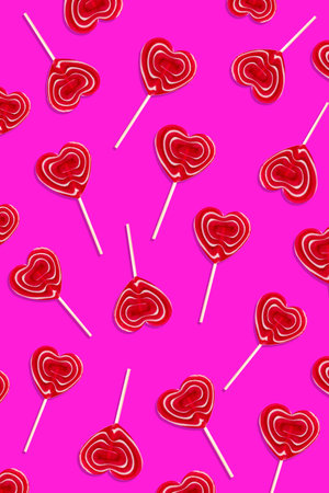 Red heart lollipops pattern on purple background, card for Valentines Day celebration.の写真素材