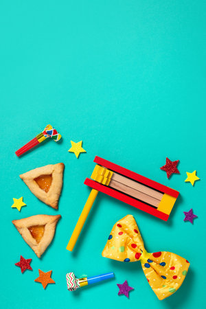 Purim border, carnival background with traditional hamantaschen cookies, costume accessories and decor on bright green background, copy spaceの写真素材
