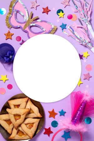 Purim carnival frame with traditional cookies, costume accessories and decor on pastel violet background, copy space, toned imageの写真素材