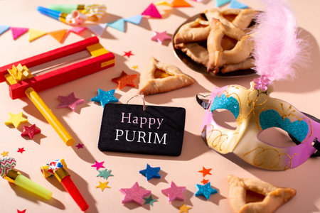 Purim carnival background with traditional hamantaschen cookies, carnival mask, black board with quote Happy Purim, holiday decor in hard light, copy spaceの写真素材