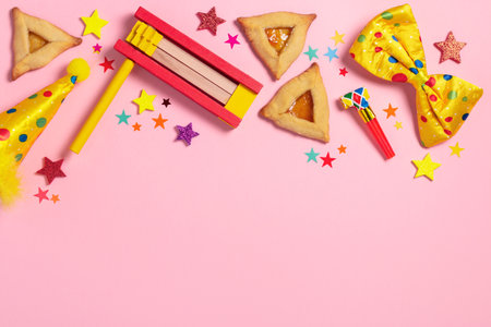 Purim carnival frame with traditional cookies, costume accessories and decor on pastel pink backgroundの写真素材