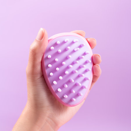 Woman holding in hand scalp massage and cleansing shampoo brush on purple background, closeupの写真素材
