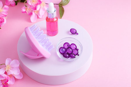 Scalp Massage and Cleansing Shampoo Brush with hair vitamins on pink backgroundの写真素材